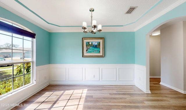 spare room with light hardwood / wood-style flooring, plenty of natural light, and a chandelier