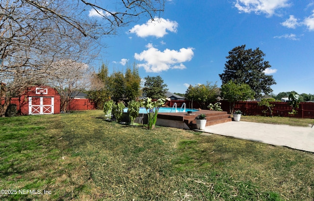 view of yard featuring a fenced in pool, a patio area, and a storage shed