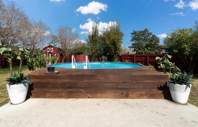 view of pool featuring a shed and a wooden deck