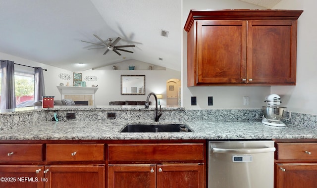 kitchen featuring sink, dishwasher, ceiling fan, light stone countertops, and vaulted ceiling