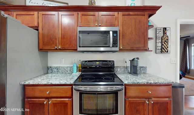 kitchen with light stone counters and appliances with stainless steel finishes