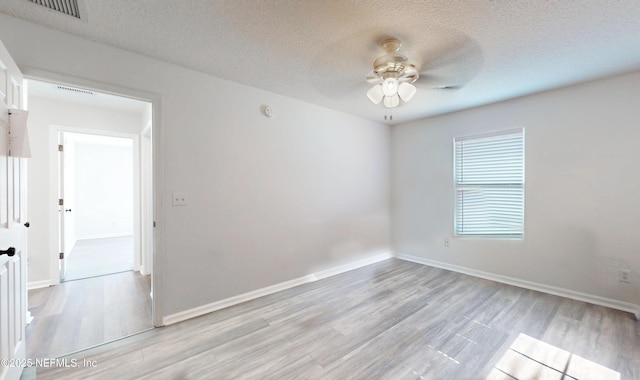 unfurnished room with a textured ceiling, light hardwood / wood-style flooring, and ceiling fan