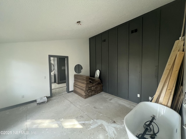 interior space with vaulted ceiling and a textured ceiling