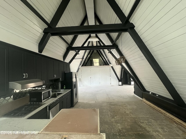 kitchen with appliances with stainless steel finishes, sink, and vaulted ceiling with beams