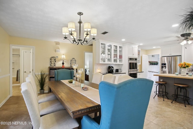 dining area with ceiling fan with notable chandelier