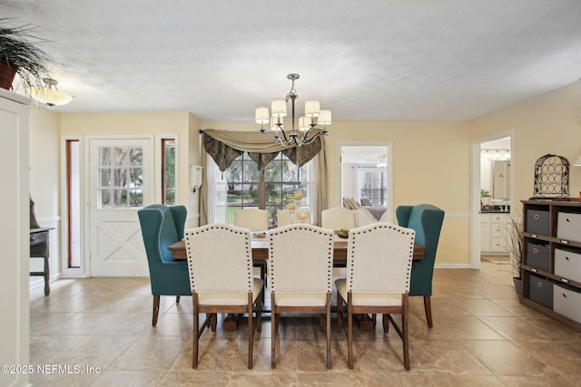 tiled dining space with a textured ceiling and a chandelier