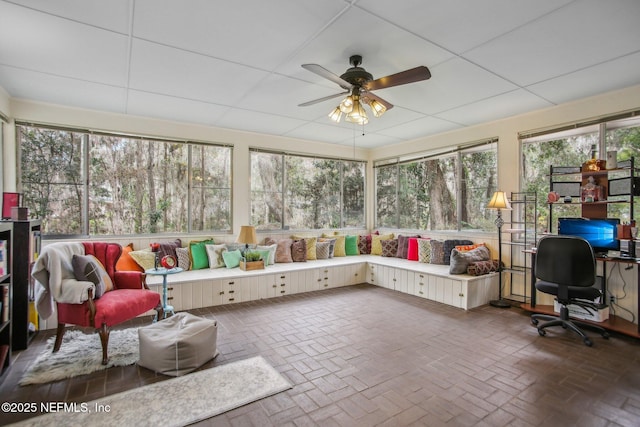 sunroom / solarium featuring ceiling fan