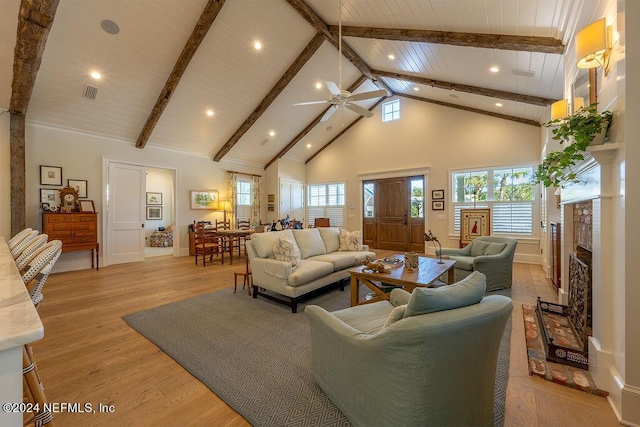 living room featuring beamed ceiling, plenty of natural light, high vaulted ceiling, and light hardwood / wood-style floors