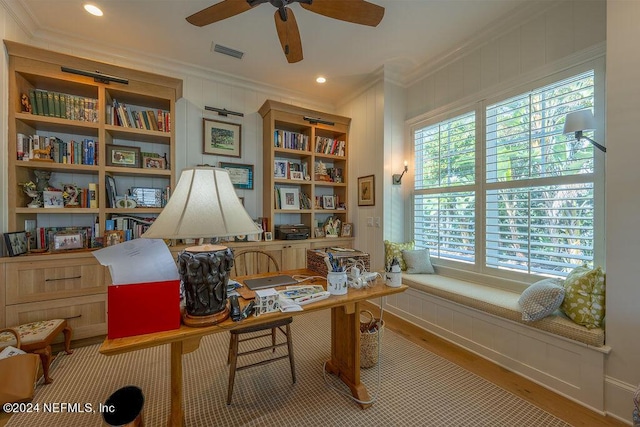 living area with crown molding, ceiling fan, built in features, and light hardwood / wood-style floors