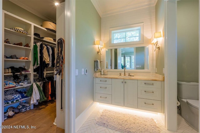 bathroom with crown molding, vanity, toilet, and hardwood / wood-style flooring