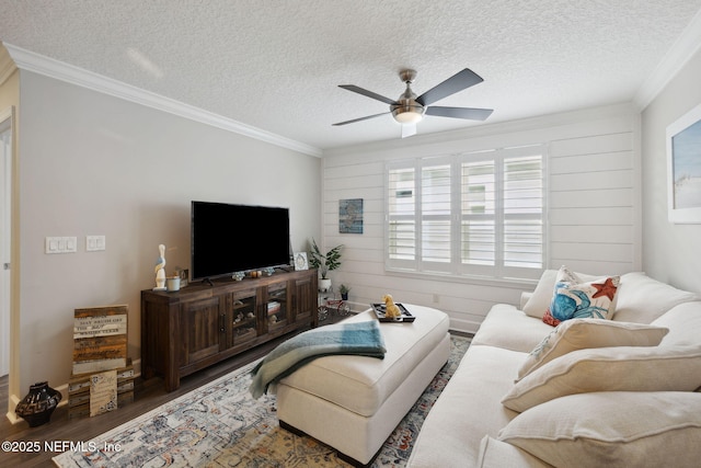 living room featuring hardwood / wood-style flooring, ceiling fan, crown molding, and a textured ceiling