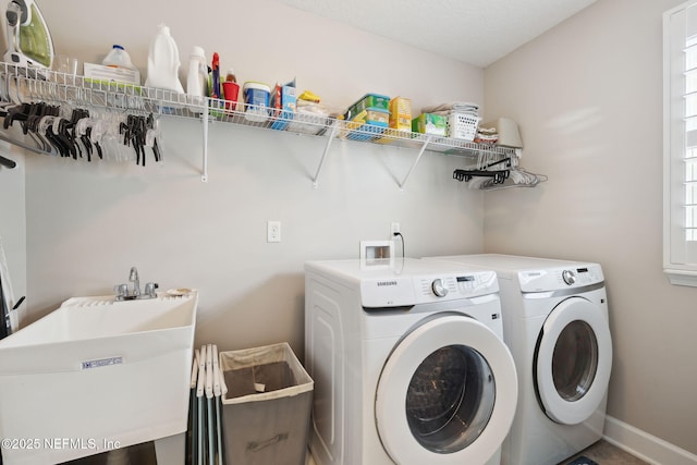 washroom with separate washer and dryer and sink