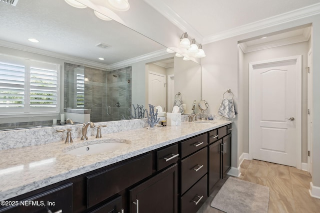 bathroom with ornamental molding, an enclosed shower, and vanity