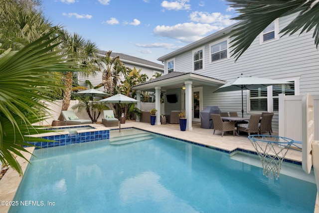 view of pool with an in ground hot tub, grilling area, and a patio area