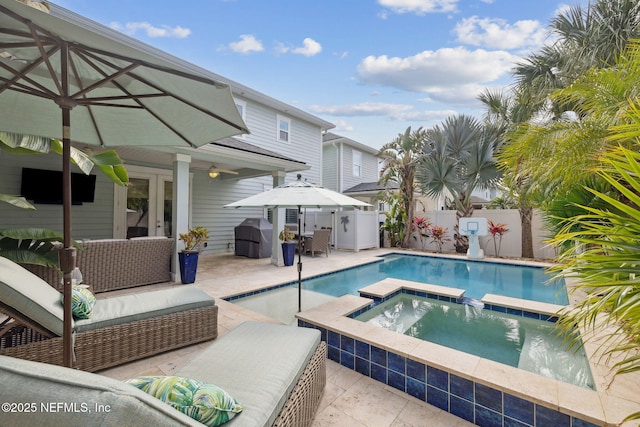 view of pool with an in ground hot tub, outdoor lounge area, a patio area, and french doors