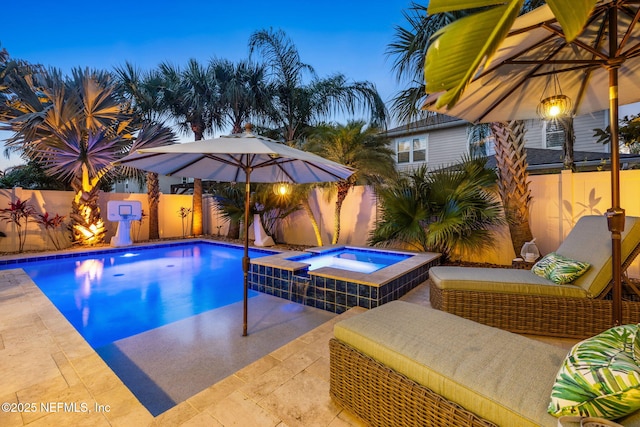 view of swimming pool featuring a pool with connected hot tub, a patio, and a fenced backyard