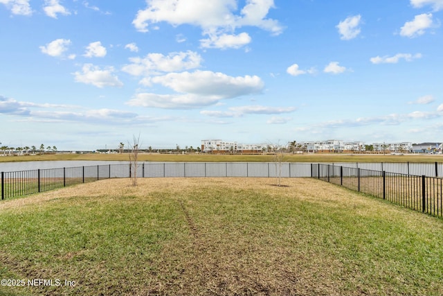 view of yard with a water view and fence