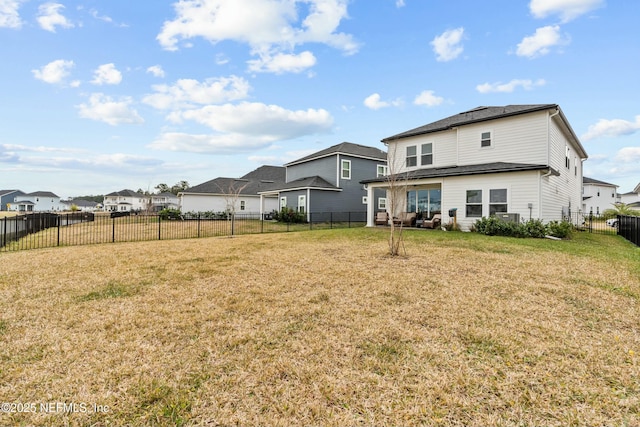 back of property with a yard, a fenced backyard, and a residential view