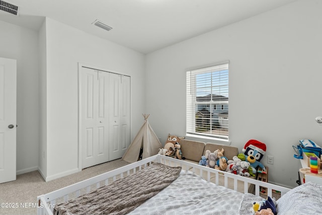 carpeted bedroom featuring a closet, visible vents, and baseboards