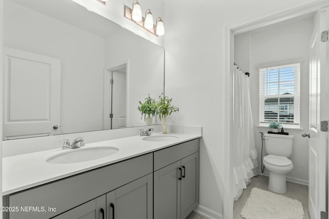 full bathroom with a shower with shower curtain, a sink, toilet, and double vanity