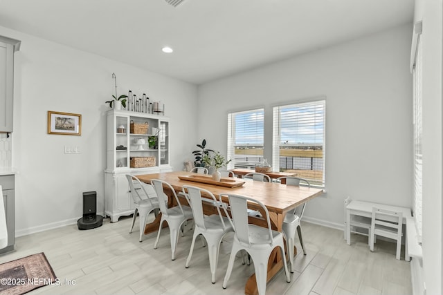 dining area with light wood-style flooring, baseboards, and recessed lighting