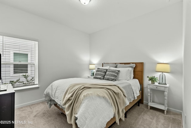 bedroom featuring light carpet and baseboards