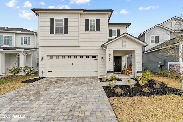 view of front facade featuring decorative driveway and an attached garage