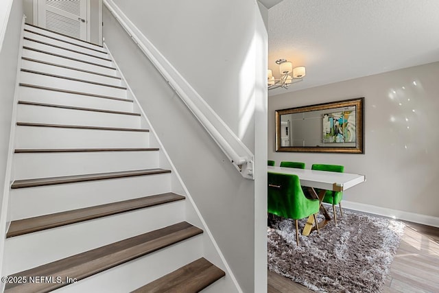 staircase featuring hardwood / wood-style flooring and a textured ceiling