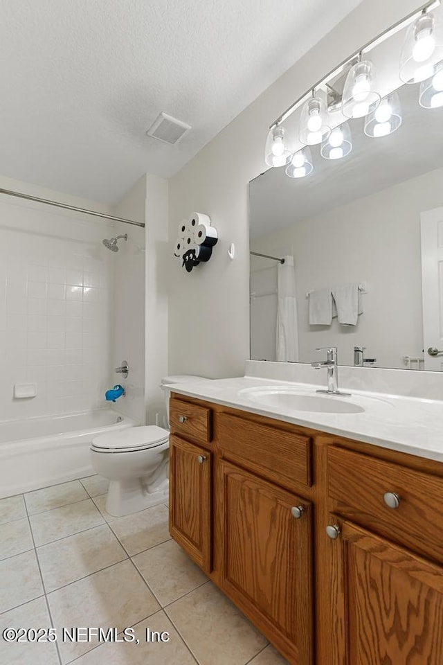 full bathroom featuring tiled shower / bath, vanity, toilet, tile patterned floors, and a textured ceiling