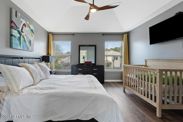 bedroom with lofted ceiling, multiple windows, dark hardwood / wood-style floors, and ceiling fan
