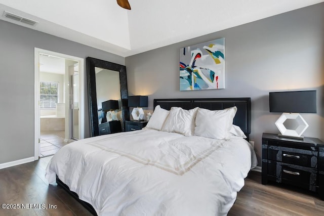 bedroom with dark hardwood / wood-style floors, ceiling fan, and ensuite bathroom