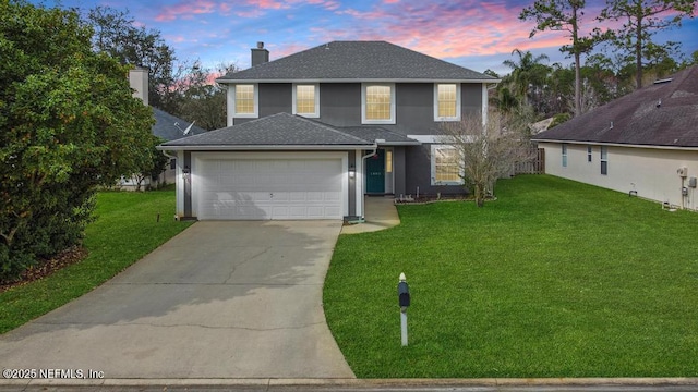 front of property with a garage and a lawn