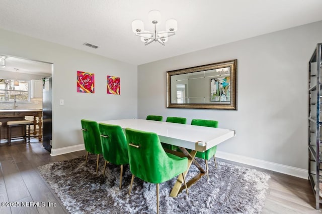 dining room featuring hardwood / wood-style floors and a notable chandelier