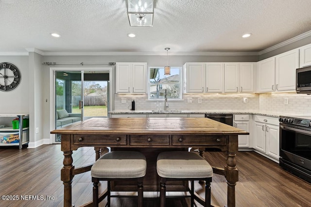 kitchen with white cabinetry, appliances with stainless steel finishes, sink, and decorative light fixtures