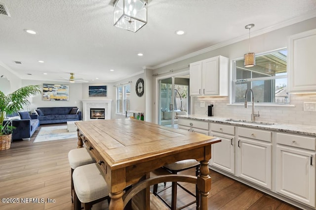 kitchen with white cabinetry, sink, and light stone countertops
