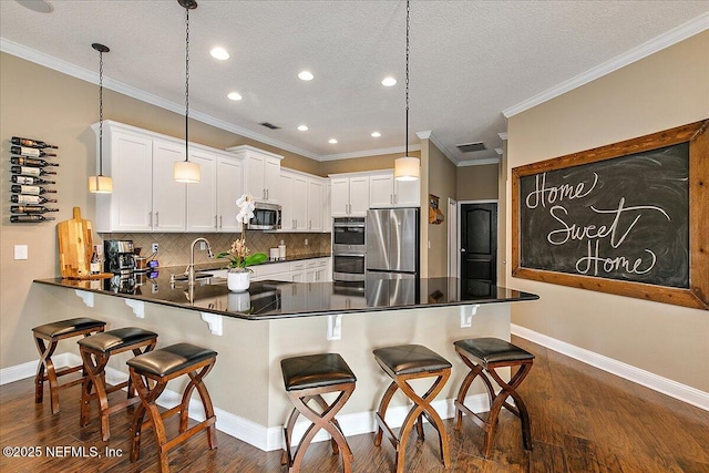 721 W Kings College Dr, Saint Johns, FL 32259 - kitchen with stainless steel appliances, decorative light fixtures, kitchen peninsula, and white cabinets