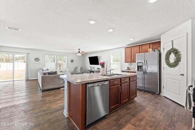 kitchen featuring sink, a kitchen island with sink, stainless steel appliances, plenty of natural light, and dark wood-type flooring