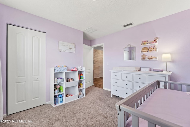 carpeted bedroom with a textured ceiling and a closet