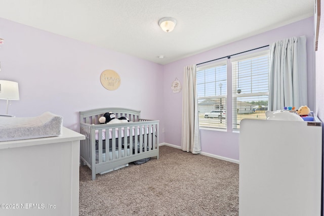 bedroom featuring a nursery area and light colored carpet