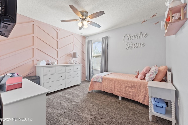 carpeted bedroom featuring ceiling fan and a textured ceiling