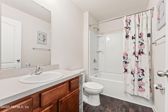 full bathroom featuring wood-type flooring, vanity, toilet, a textured ceiling, and shower / bath combo with shower curtain