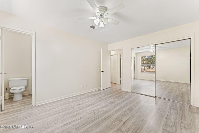 unfurnished bedroom with connected bathroom, light hardwood / wood-style flooring, a closet, and ceiling fan