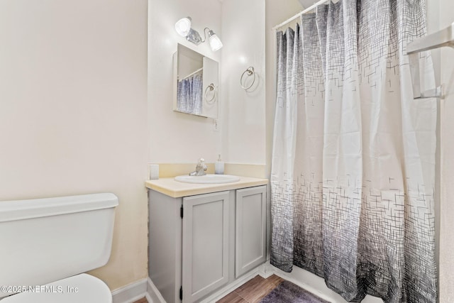 bathroom featuring vanity, walk in shower, and toilet