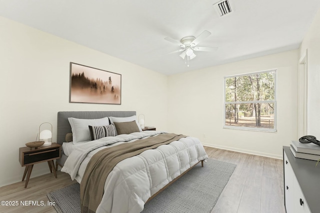 bedroom with light wood-style flooring, baseboards, visible vents, and ceiling fan