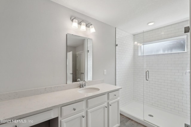 full bathroom with a shower stall and vanity