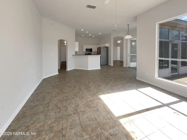 unfurnished living room with tile patterned floors and ceiling fan