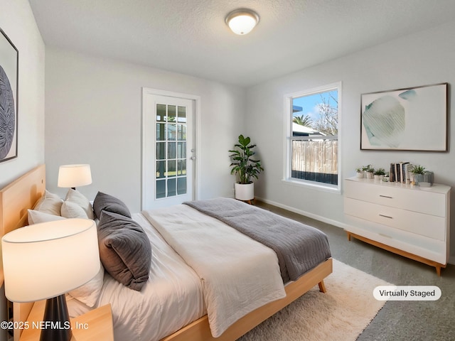 bedroom with multiple windows, a textured ceiling, and carpet