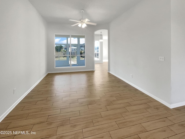 empty room with ceiling fan and light hardwood / wood-style flooring