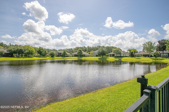 view of water feature with a residential view and fence