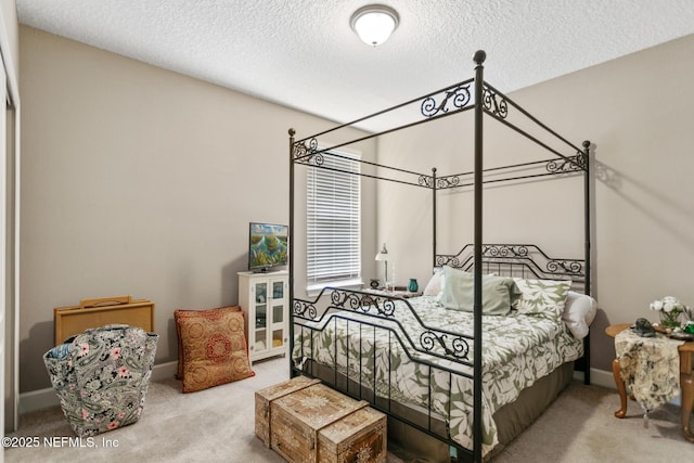 carpeted bedroom featuring baseboards and a textured ceiling